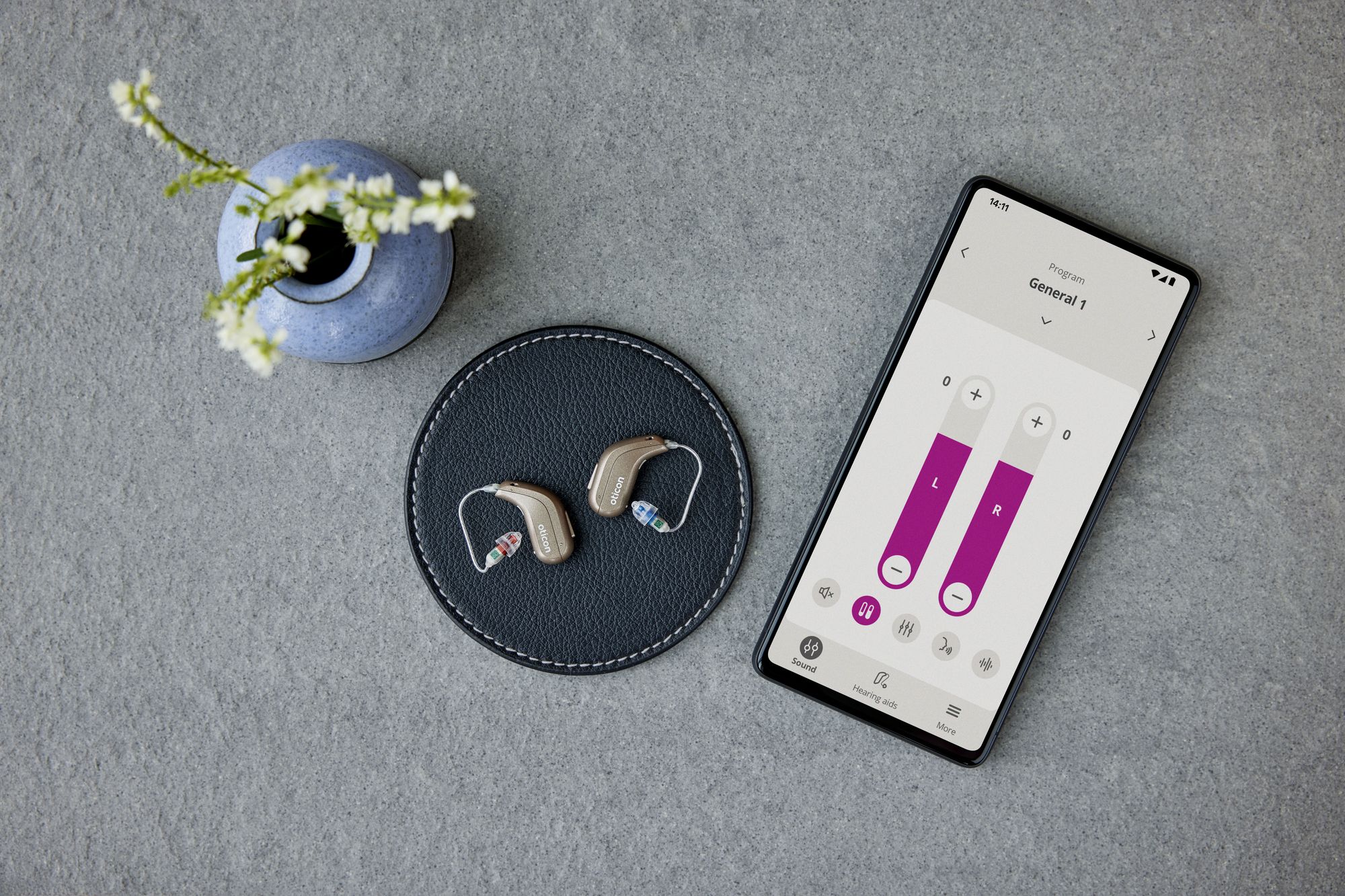 Hörgeräte neben Handy und App für Steuerung von Hörgeräten